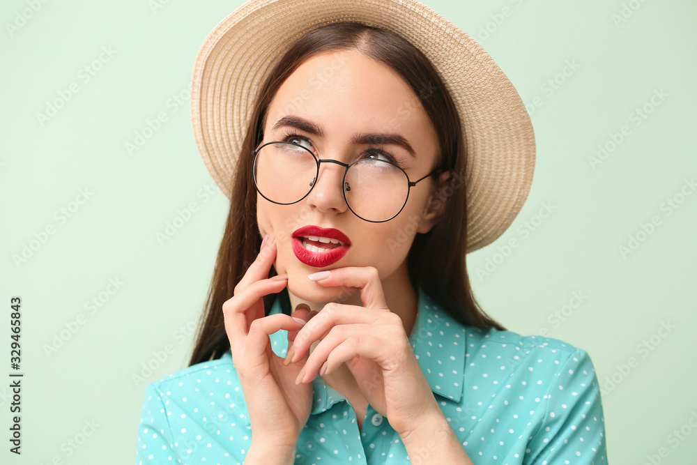 Thoughtful young woman on color background