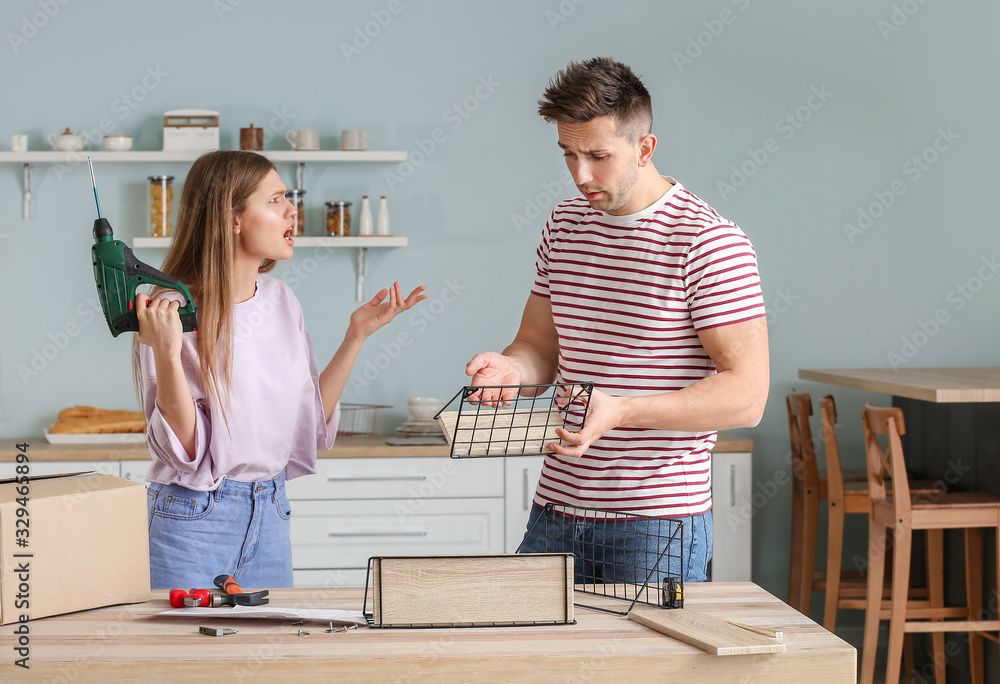 Emotional couple assembling furniture at home