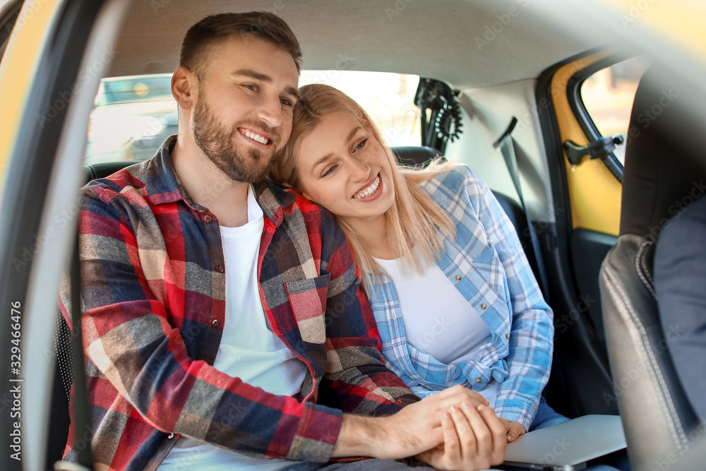 Portrait of young couple sitting in taxi