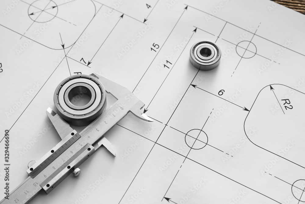 Bearings with vernier caliper and drawings on table of engineer