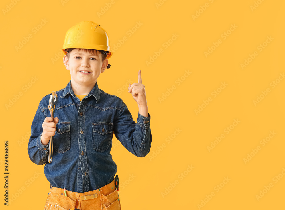 Cute little builder with raised index finger on color background