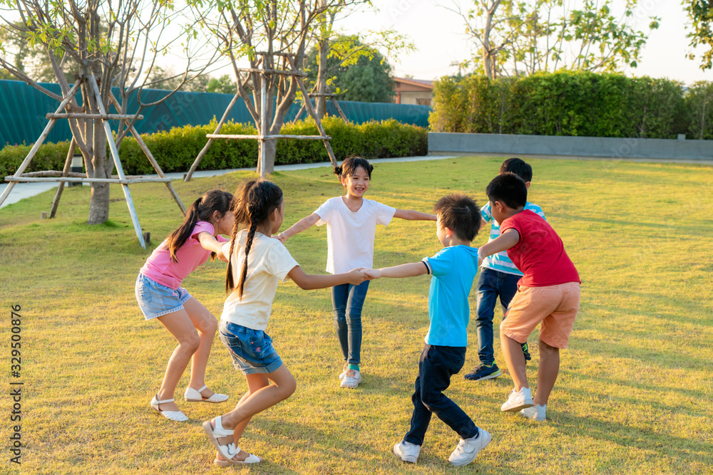 Large group of happy Asian smiling kindergarten kids friends holding hands playing and dancing play 