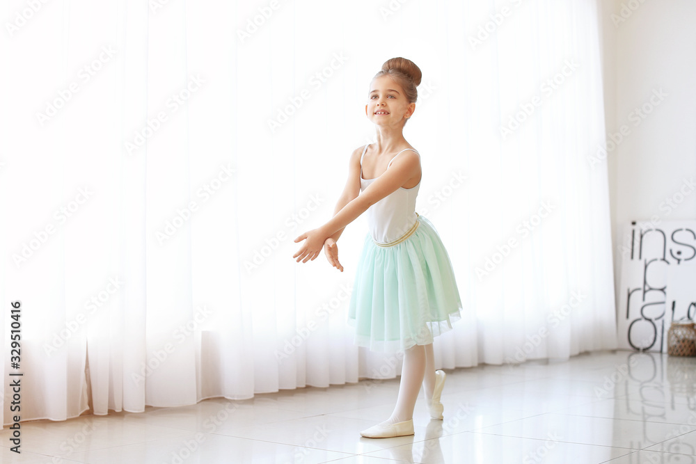 Cute little ballerina in dance studio