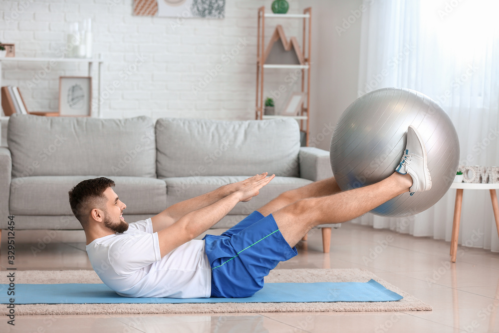 Sporty young man training at home