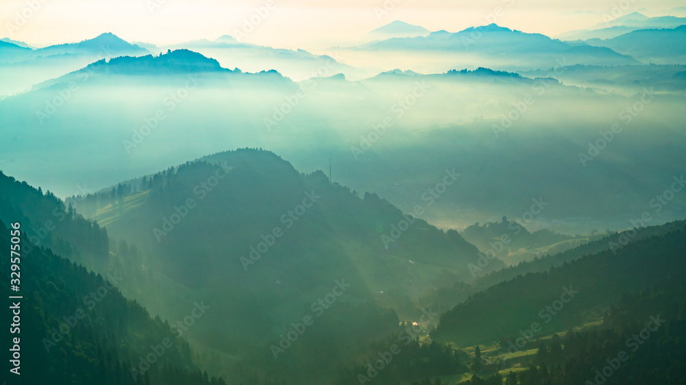 清晨的阳光下，美丽的青山；山谷中的雾景