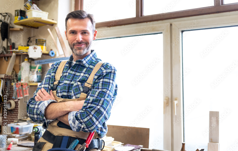 Portrait of middle aged carpenter in the carpentry workshop