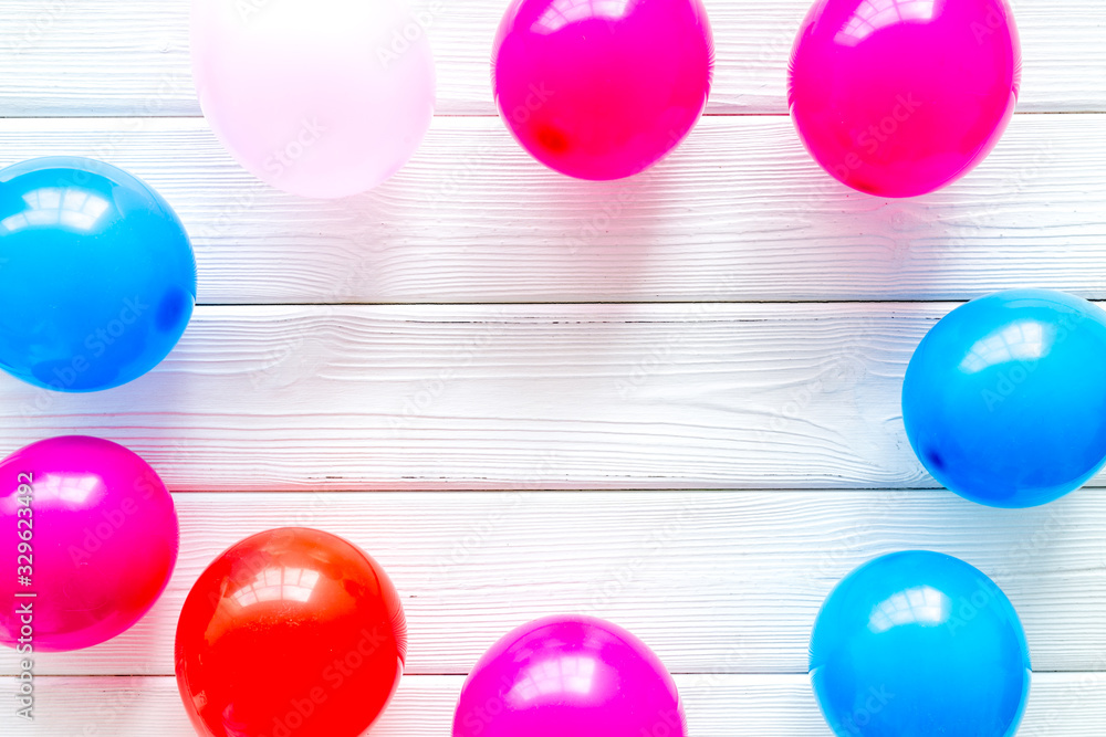 Decorative frame with colorful balloons on white wooden background top-down frame copy space