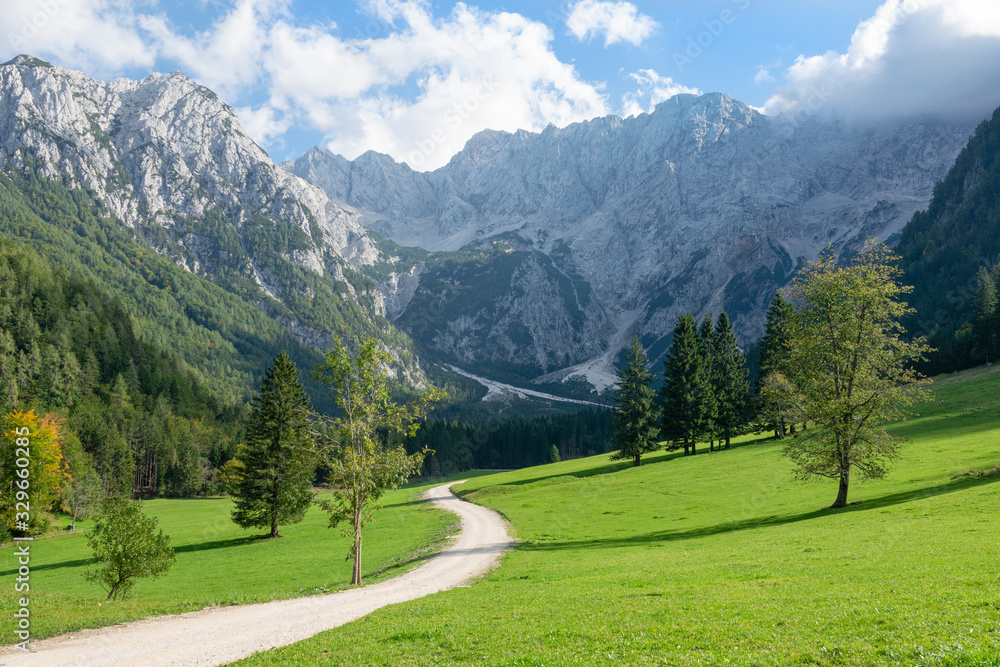 Scenic view of the idyllic countryside underneath a spectacular rocky ridge.