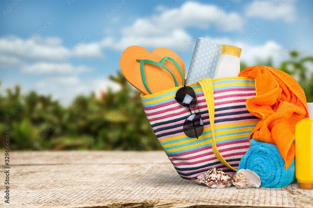 Bag,  flip flops, sunglasses and hat on the beach