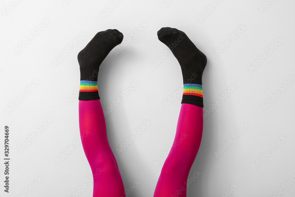 Legs of young woman in socks and tights on light background