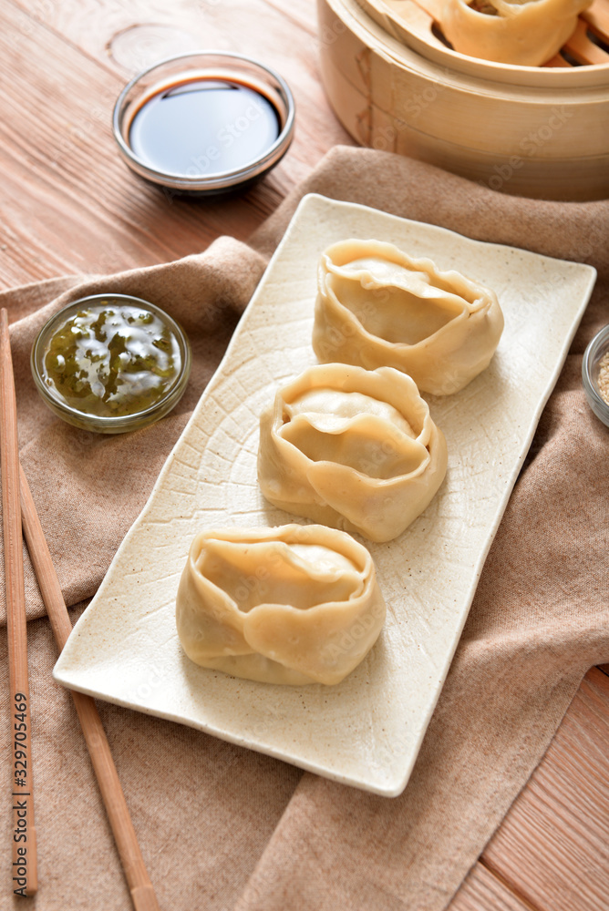 Plate with oriental dumplings on table