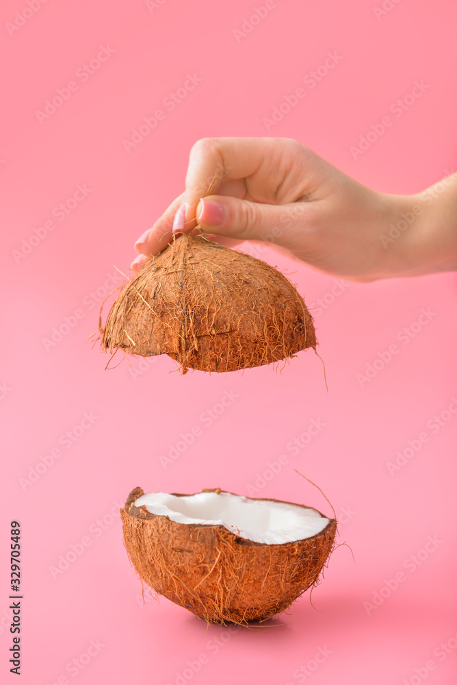 Female hand with tasty coconut on color background