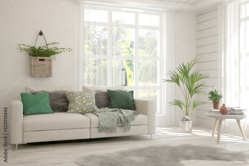 Minimalist living room in white color with sofa and summer landscape in window. Scandinavian interio