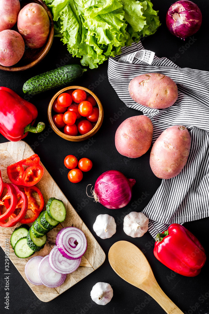 Autumn harvest. Vegetables - potato,cucumber, corn, greenery - on black background top-down