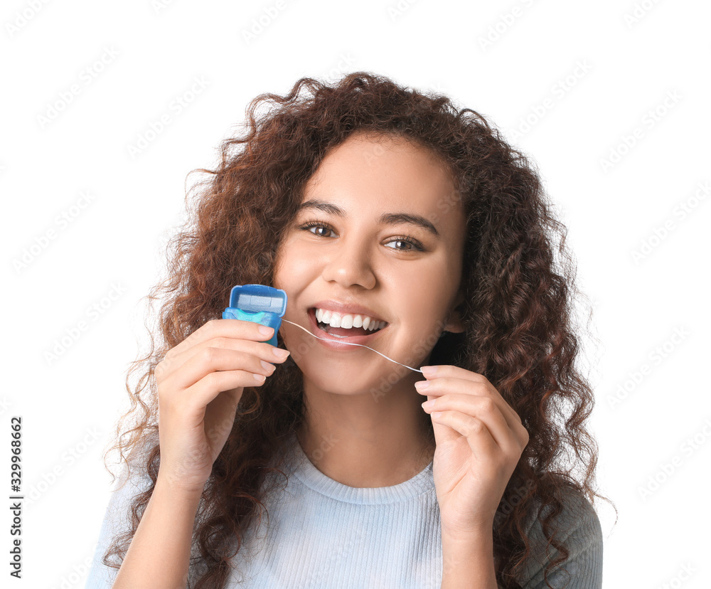 Young woman with dental floss on white background