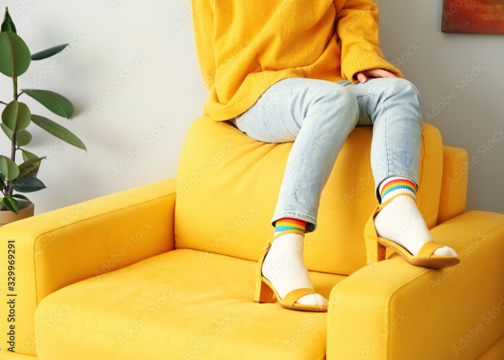 Young woman in socks and sandals at home