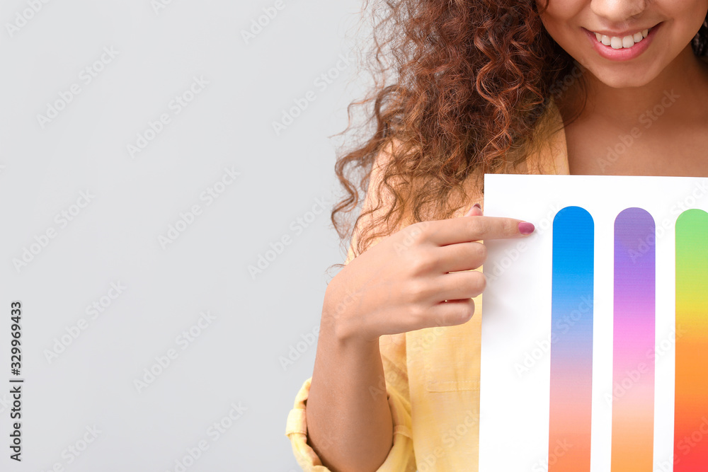 African-American woman with color palettes on grey background