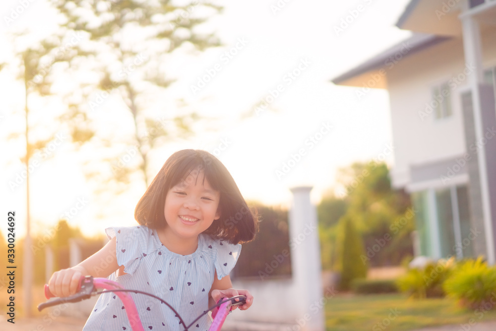 6 years old happy Little asian girl child showing front teeth with big smile and laughing she ride b