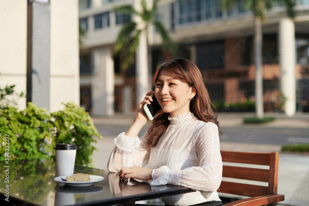 年轻女子在咖啡馆喝咖啡，打手机