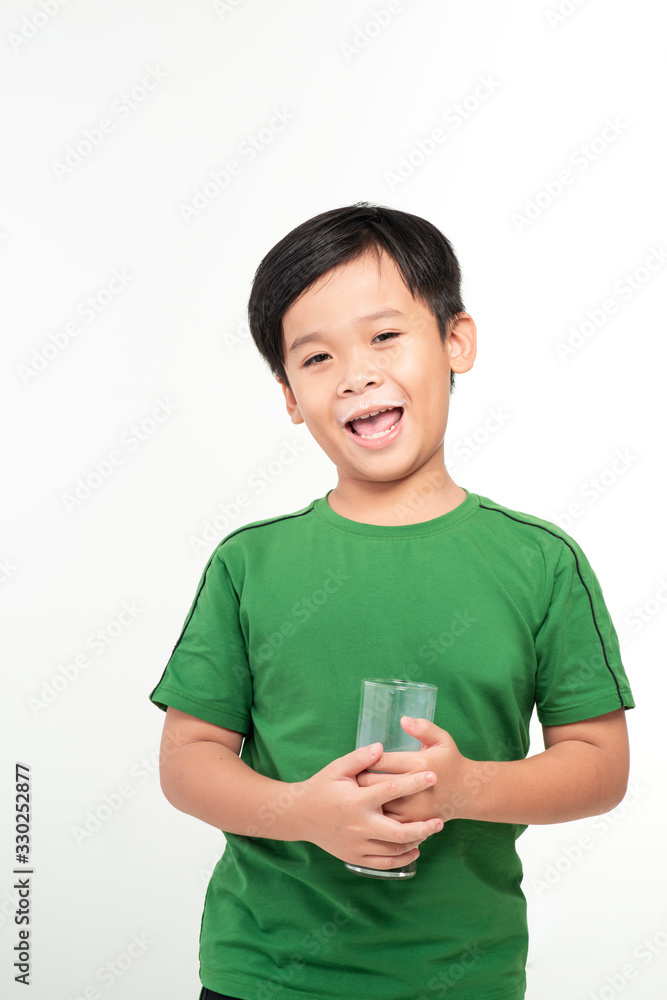 Cute boy drinking milk on light background