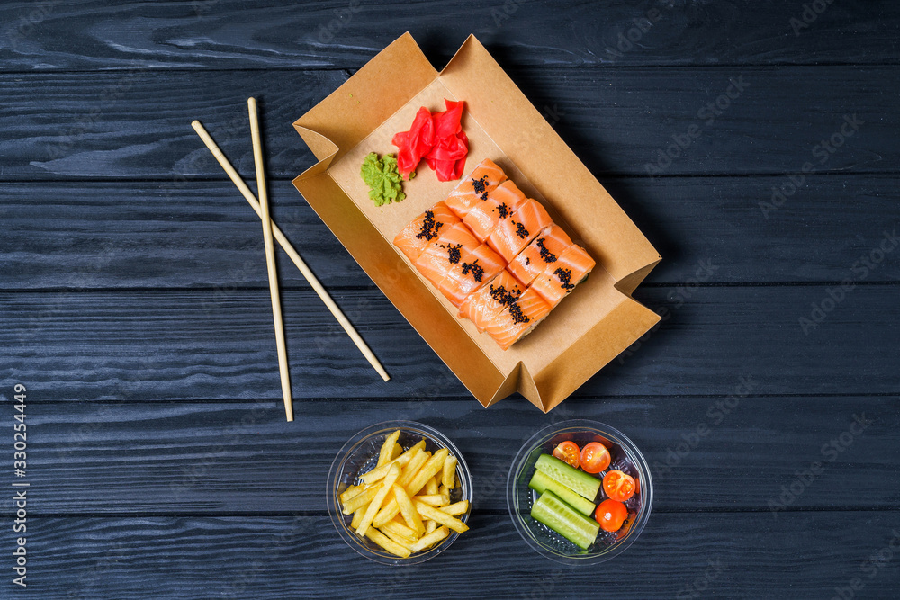 Food delivery, sushi rolls. Set of sushi in a cardboard box. Japanese Traditional Cuisine.