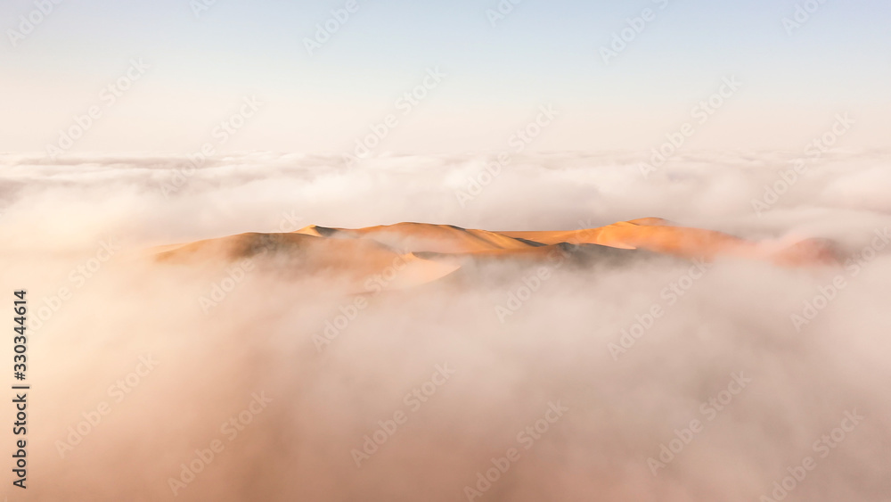 空旷地区被冬季晨雾云包围的巨大沙丘鸟瞰图。Liwa des