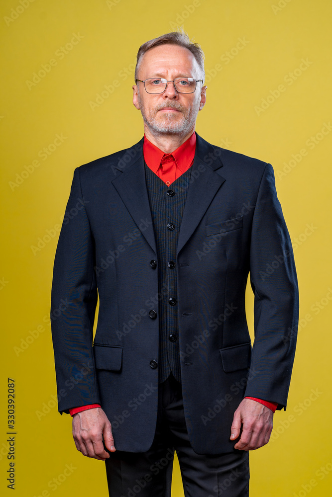 Content senior business man smiling in a dark suit. Hands straight. Red shirt. Confident. Business s