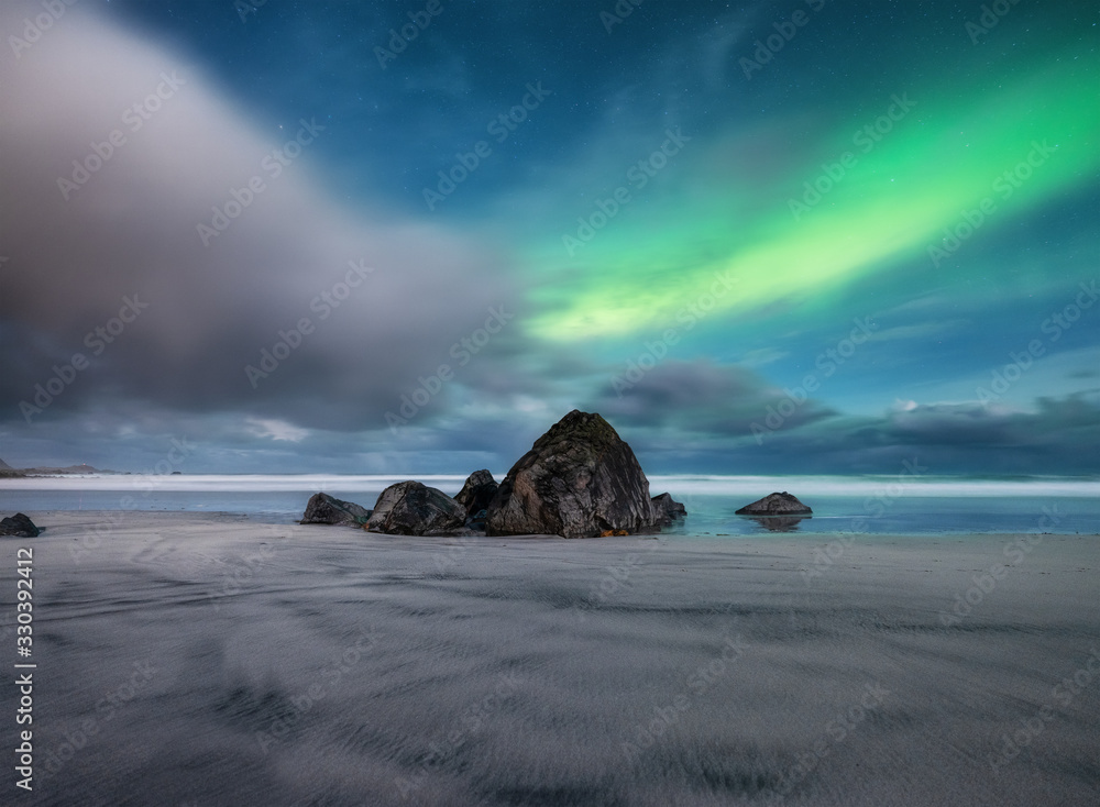 Aurora Borealis. Skagsanden beach on Lofoten Islands, Norway.. Stars and northern light. Reflections