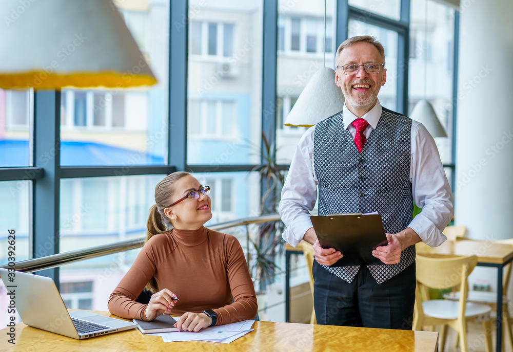 Senior businessman discussing business ideas with the assistance. Mature man and businesswoman in an