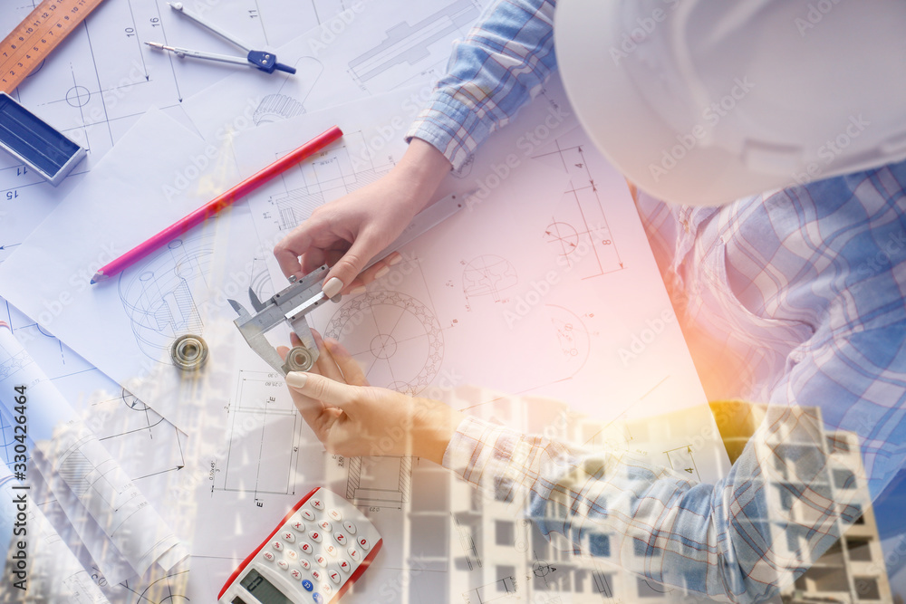 Double exposure of unfinished building and female architect working in office