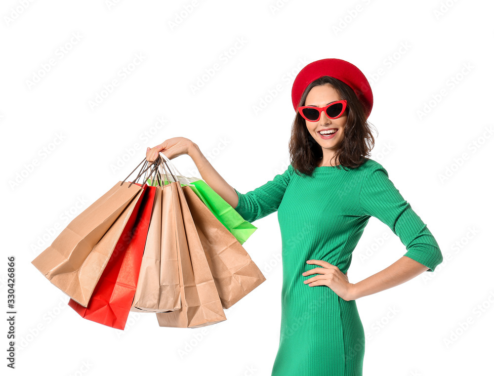 Beautiful young woman with shopping bags on white background