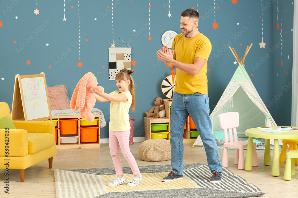 Father and his little daughter dancing at home