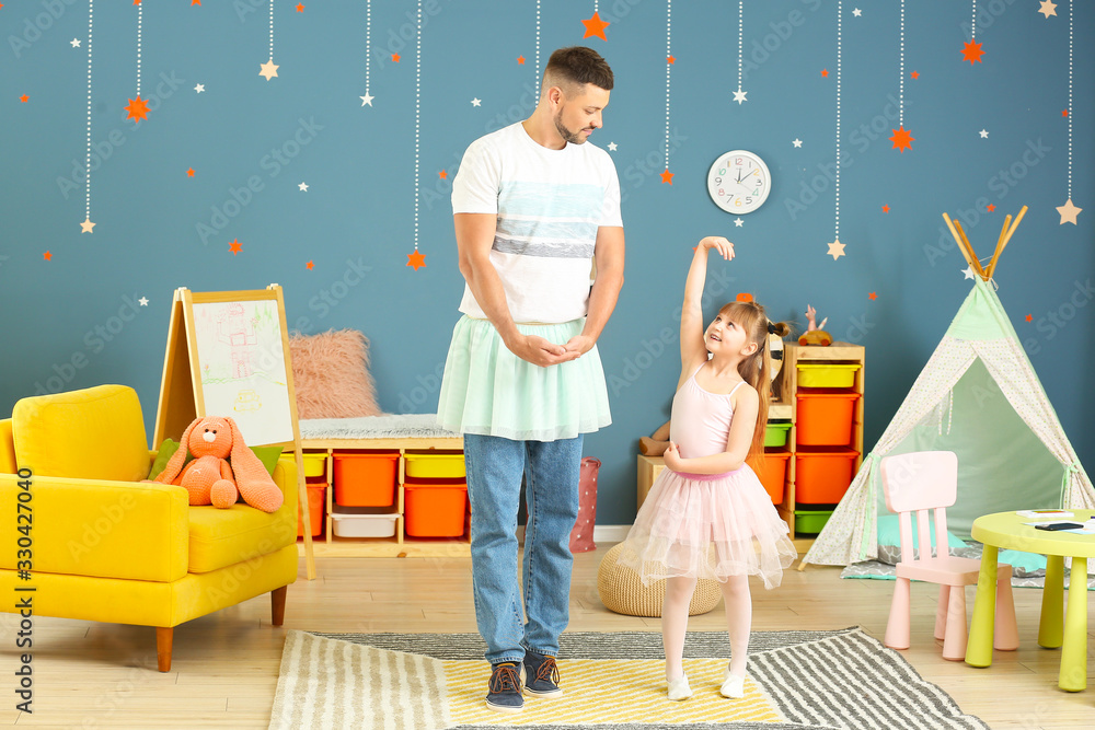 Father and his little daughter dancing at home