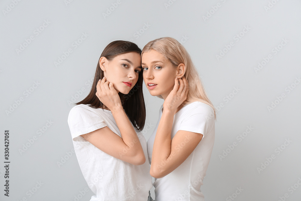 Young women with beautiful makeup on light background