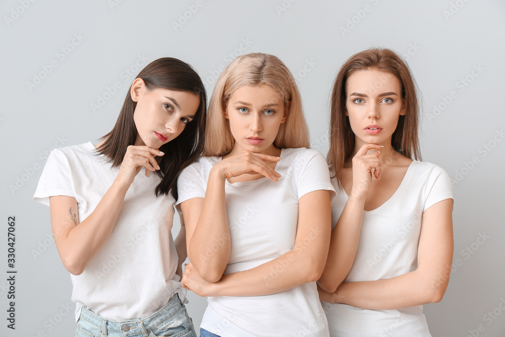 Young women with beautiful makeup on light background