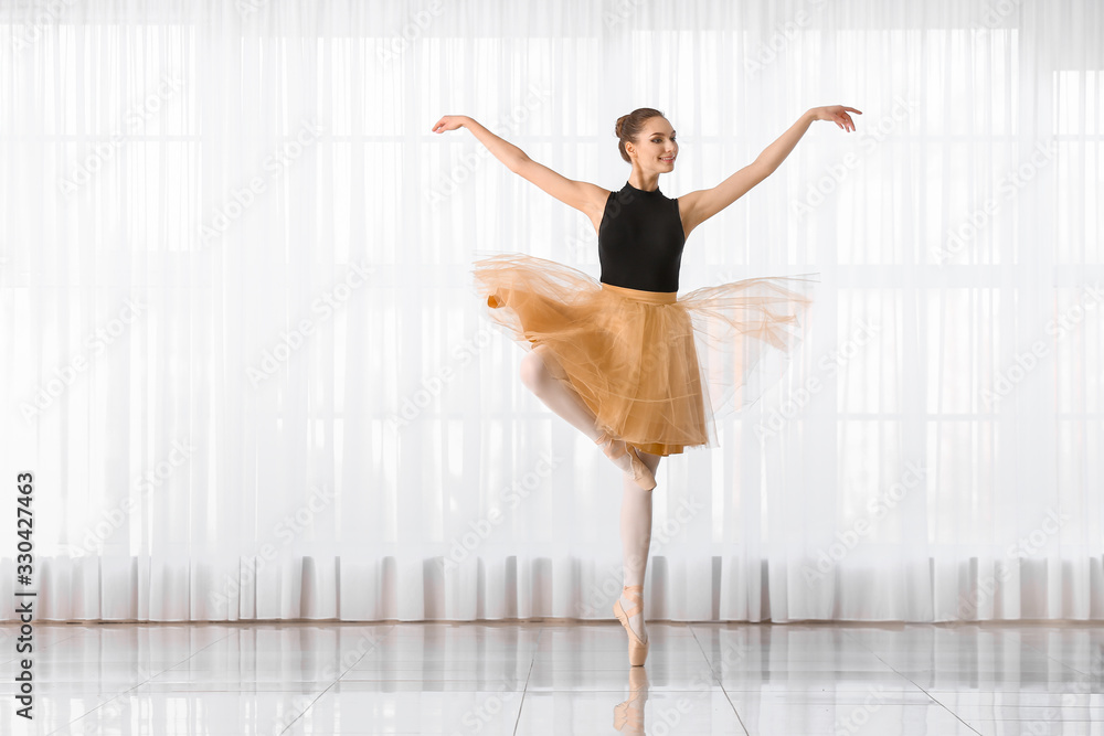 Beautiful young ballerina in dance studio