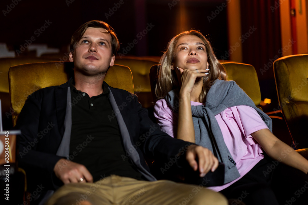 Caucasian lover enjoying to watch movie and eating popcorn together in the cinema