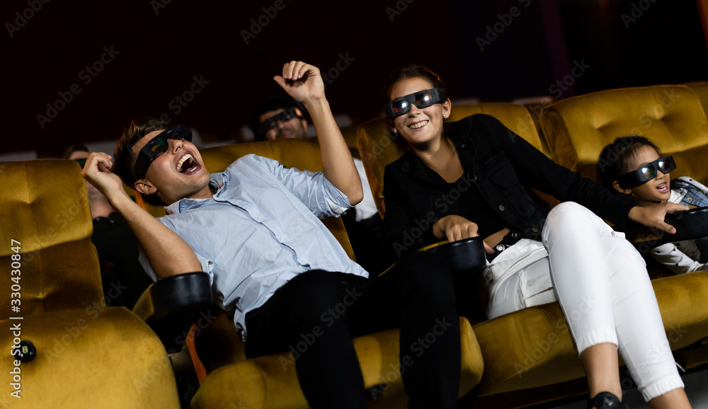 Group of people watch movie with 3D glasses in cinema theater with interest looking at the screen, e