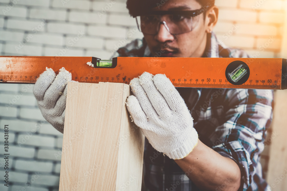 Carpenter working on wood craft at workshop to produce construction material or wooden furniture. Th