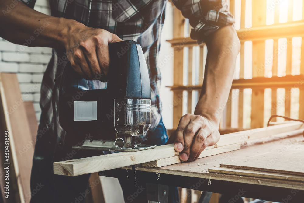 Carpenter working on wood craft at workshop to produce construction material or wooden furniture. Th