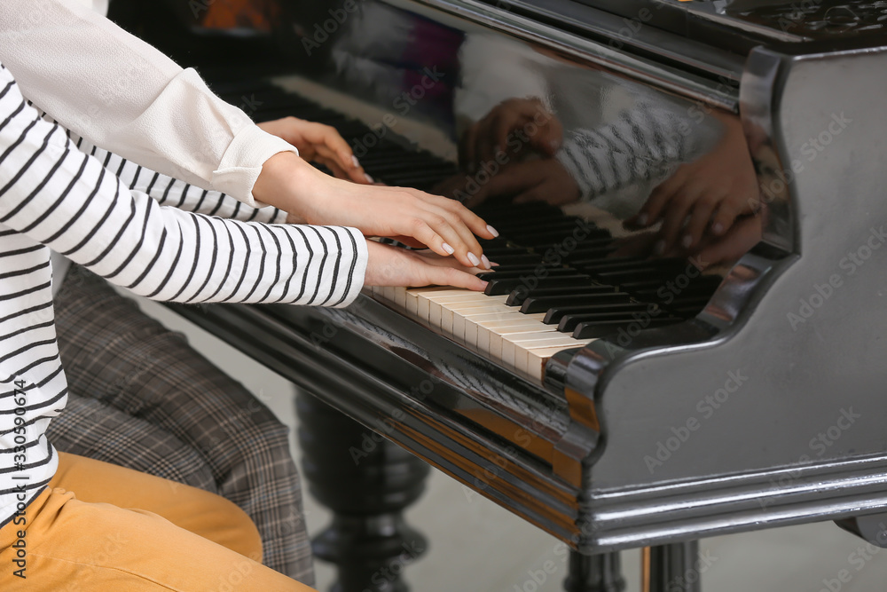 Private music teacher giving piano lessons to little boy