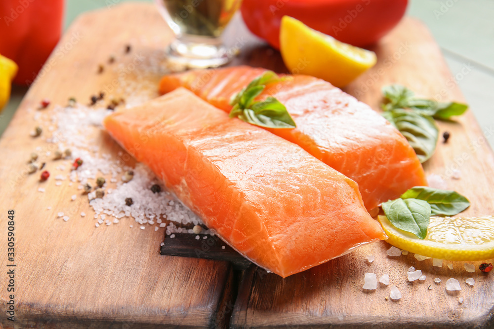 Raw salmon fillet with spices on table