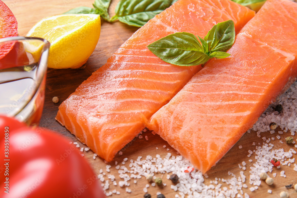 Raw salmon fillet with spices on table