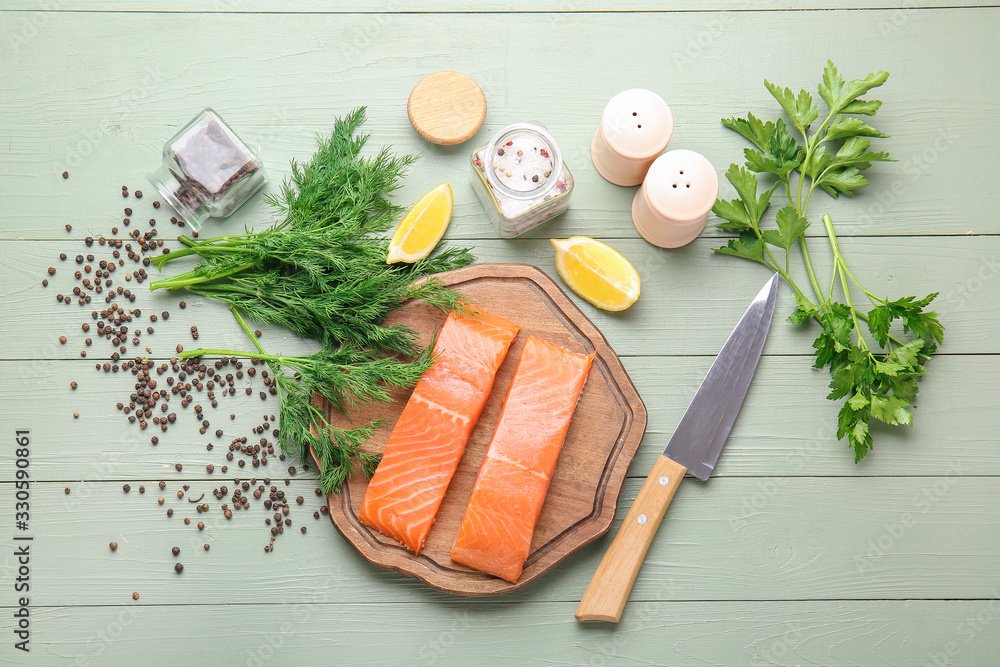 Raw salmon fillet with herbs, lemon and spices on table