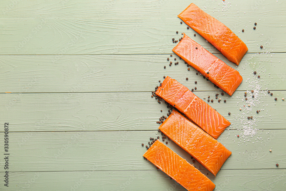 Raw salmon fillet with spices on wooden background