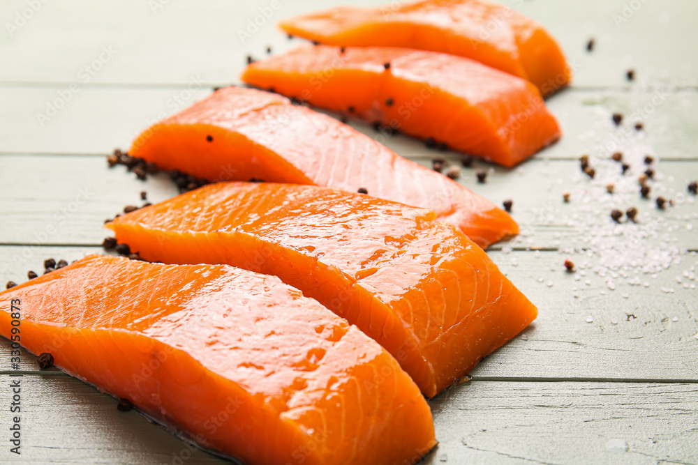 Raw salmon fillet with spices on wooden background