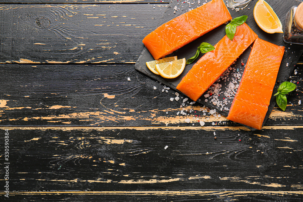 Raw salmon fillet with herbs and lemon on table