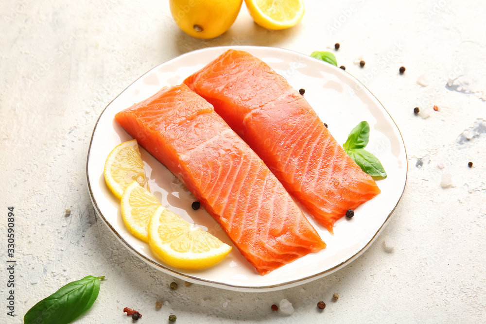 Raw salmon fillet with spices and lemon on white background