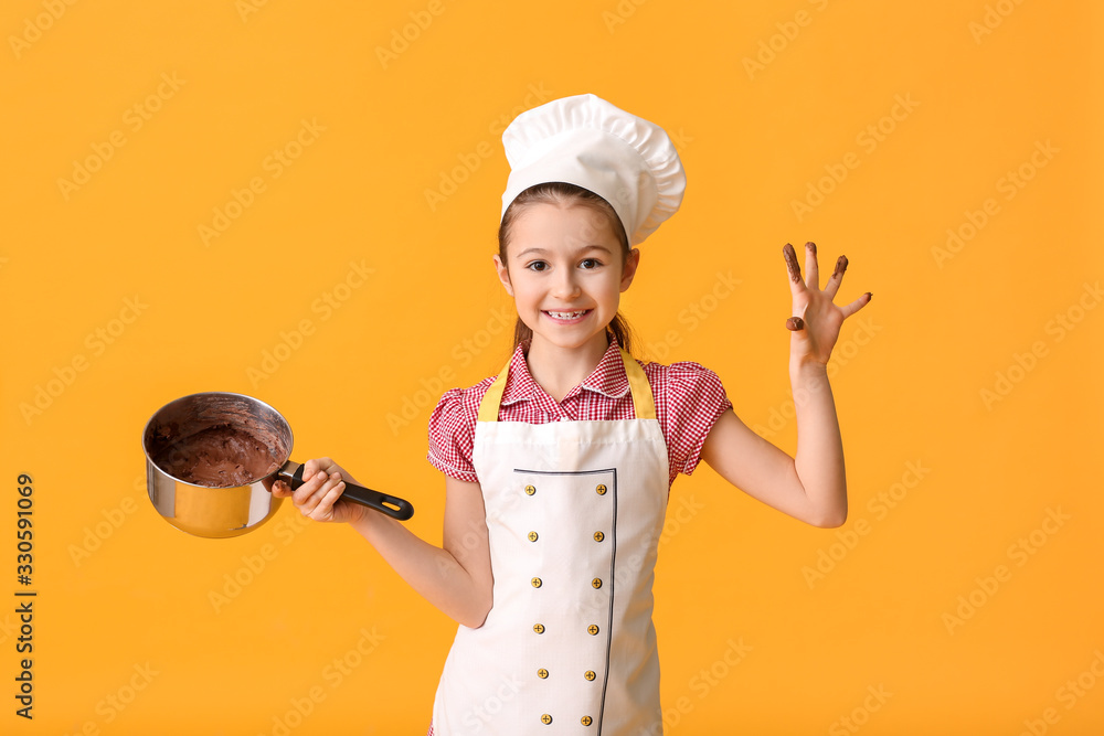 Little housewife with melted chocolate in saucepan on color background