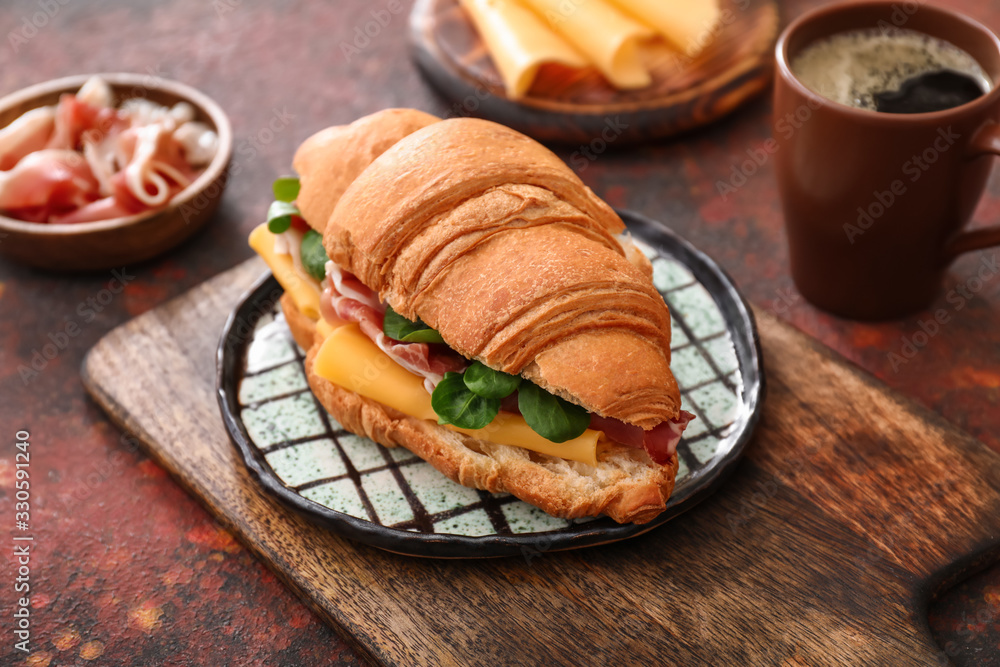 Tasty croissant sandwich on table